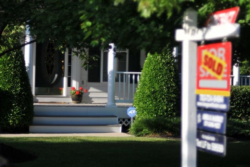 Real estate sold sign in front of a house