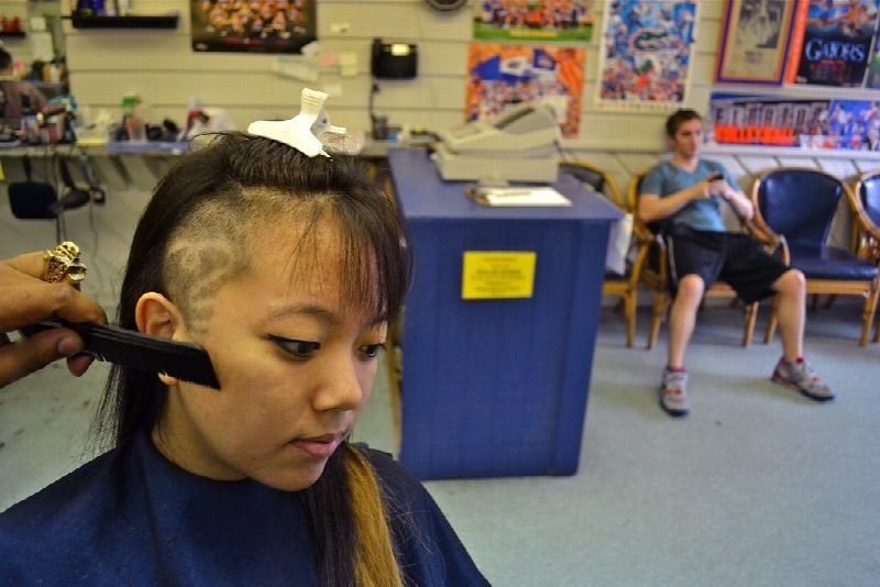 Stylist working on a woman's hair in a salon
