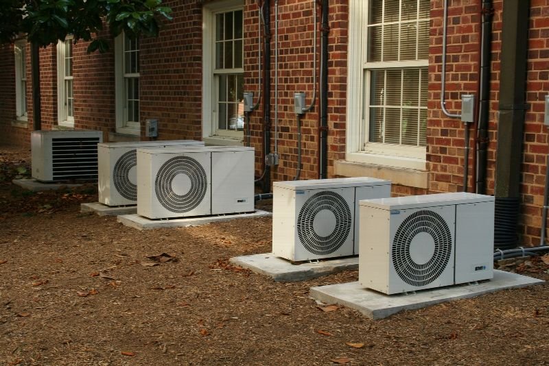 Outdoor air conditioner condenser units beside a brick building