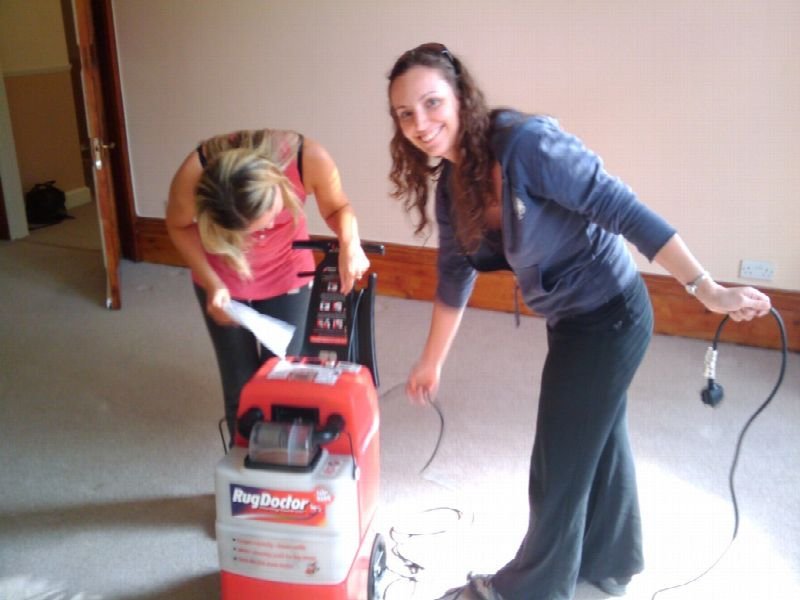 Two women using a carpet cleaning machine