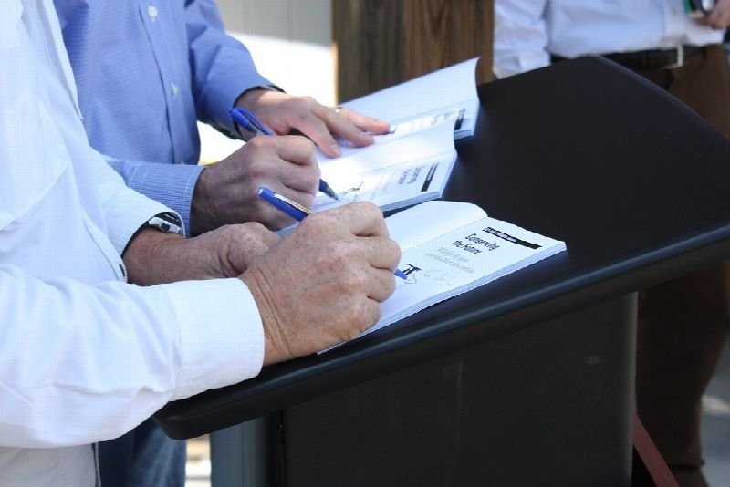 Person signing a document on a desk