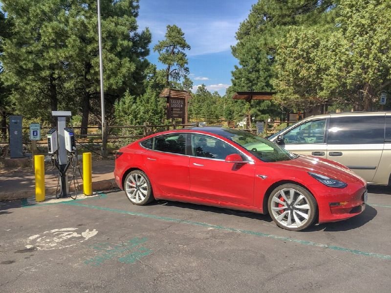 Electric car plugged into a charging station in a parking lot