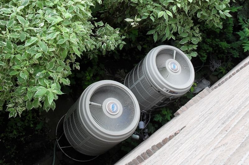 Outdoor heat pump units mounted beside a house