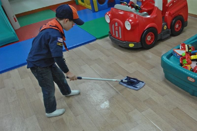 Cleaner mopping a floor in a children's play area