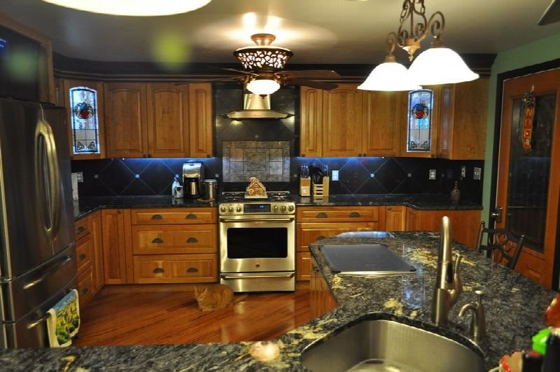 Renovated kitchen with wood cabinets and pendant lights