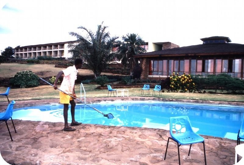 Technician cleaning an outdoor swimming pool