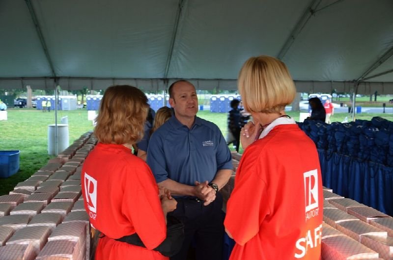 Real estate agents in matching shirts talking at an outdoor event