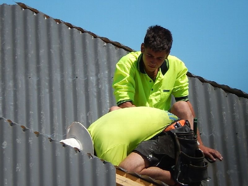 Roofer in a high-visibility shirt working on a roof