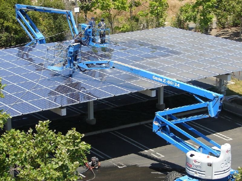 Crew using lifts to install a rooftop solar array