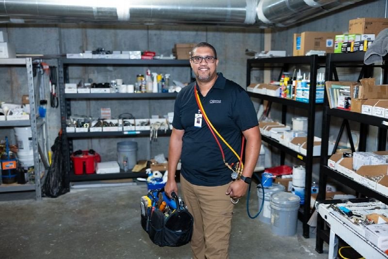 Maintenance technician carrying a tool bag in a supply room